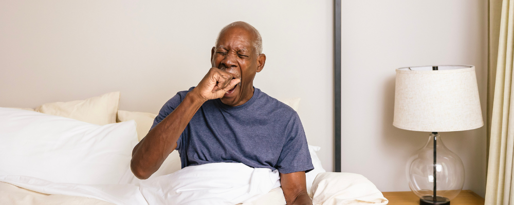 Man yawning in his bed